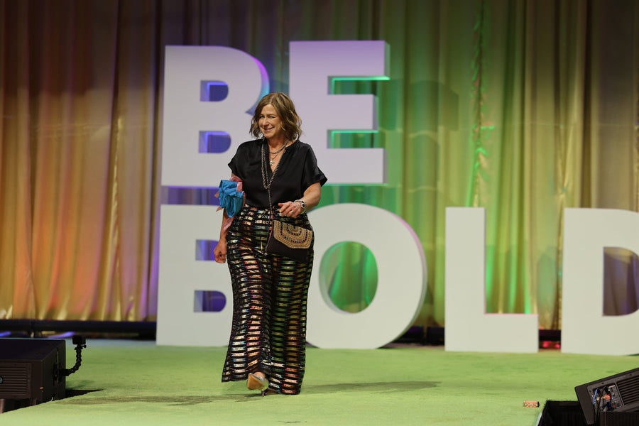 A woman walking the runway in House of Perna metallic striped pants