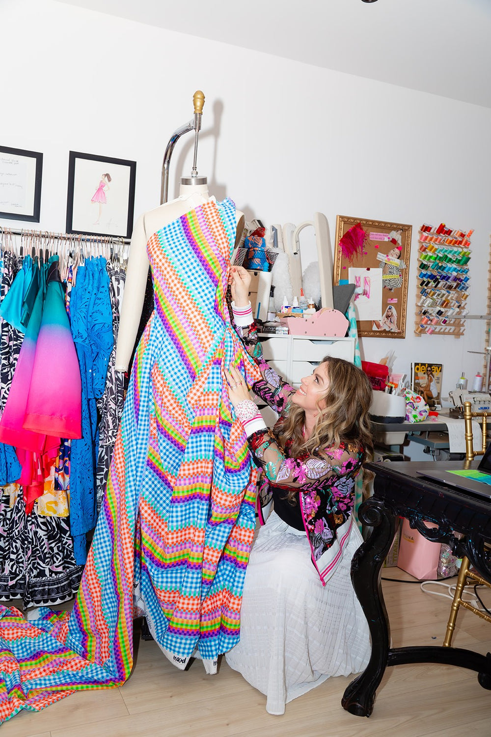 Amanda Perna draping a rainbow gingham gown on a dress form in the House of Perna atelier